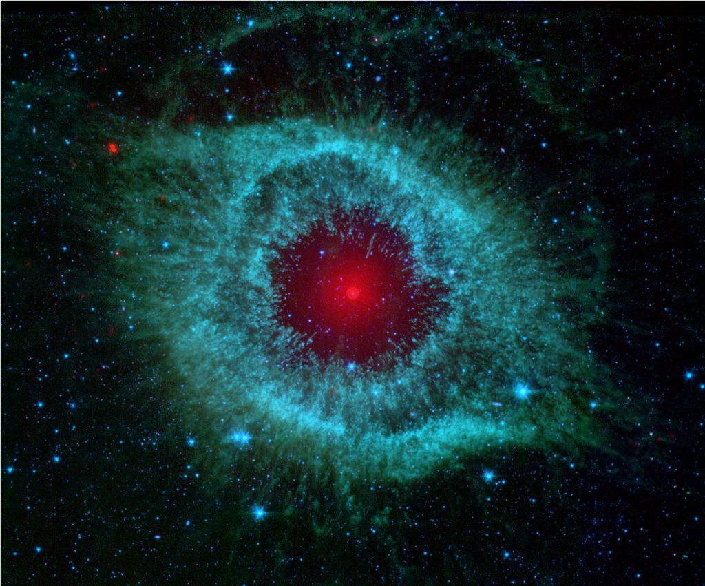 This infrared image from NASA's Spitzer Space Telescope shows the Helix nebula, a cosmic starlet often photographed by amateur astronomers for its vivid colors and eerie resemblance to a giant eye. The nebula, located about 700 light-years away in the constellation Aquarius, belongs to a class of objects called planetary nebulae. Discovered in the 18th century, these cosmic butterflies were named for their resemblance to gas-giant planets. Planetary nebulae are actually the remains of stars that once looked a lot like our sun. When sun-like stars die, they puff out their outer gaseous layers. These layers are heated by the hot core of the dead star, called a white dwarf, and shine with infrared and visible-light colors. Our own sun will blossom into a planetary nebula when it dies in about five billion years. In Spitzer's infrared view of the Helix nebula, the eye looks more like that of a green monster's. Infrared light from the outer gaseous layers is represented in blues and greens. The white dwarf is visible as a tiny white dot in the center of the picture. The red color in the middle of the eye denotes the final layers of gas blown out when the star died. The brighter red circle in the very center is the glow of a dusty disk circling the white dwarf (the disk itself is too small to be resolved). This dust, discovered by Spitzer's infrared heat-seeking vision, was most likely kicked up by comets that survived the death of their star. Before the star died, its comets and possibly planets would have orbited the star in an orderly fashion. But when the star blew off its outer layers, the icy bodies and outer planets would have been tossed about and into each other, resulting in an ongoing cosmic dust storm. Any inner planets in the system would have burned up or been swallowed as their dying star expanded. The Helix nebula is one of only a few dead-star systems in which evidence for comet survivors has been found. This image is made up of data from Spi
